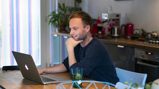 Jongeman achter laptop