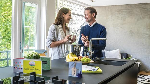 Stel viert in keuken dat ze verhuisd zijn en drinken champagne