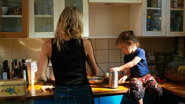 Jonge moeder met kind in de keuken