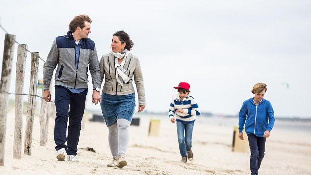 Stel waait met kinderen uit op strand en heeft het over het melden van een overlijden bij Aegon
