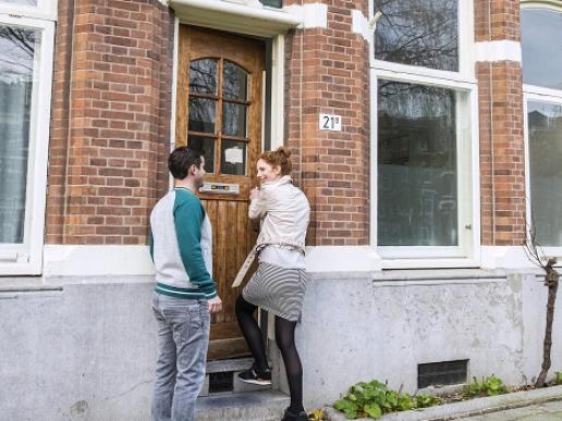 Stel opent de deur van hun nieuwe huis