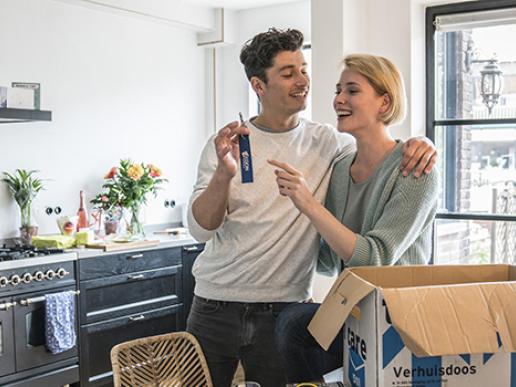 Stel met de sleutel van hun nieuwe huis